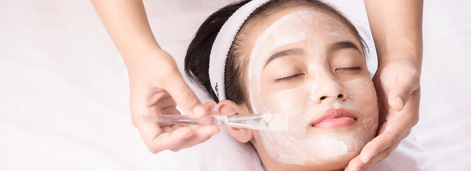Young girl with facial mask at beauty salon